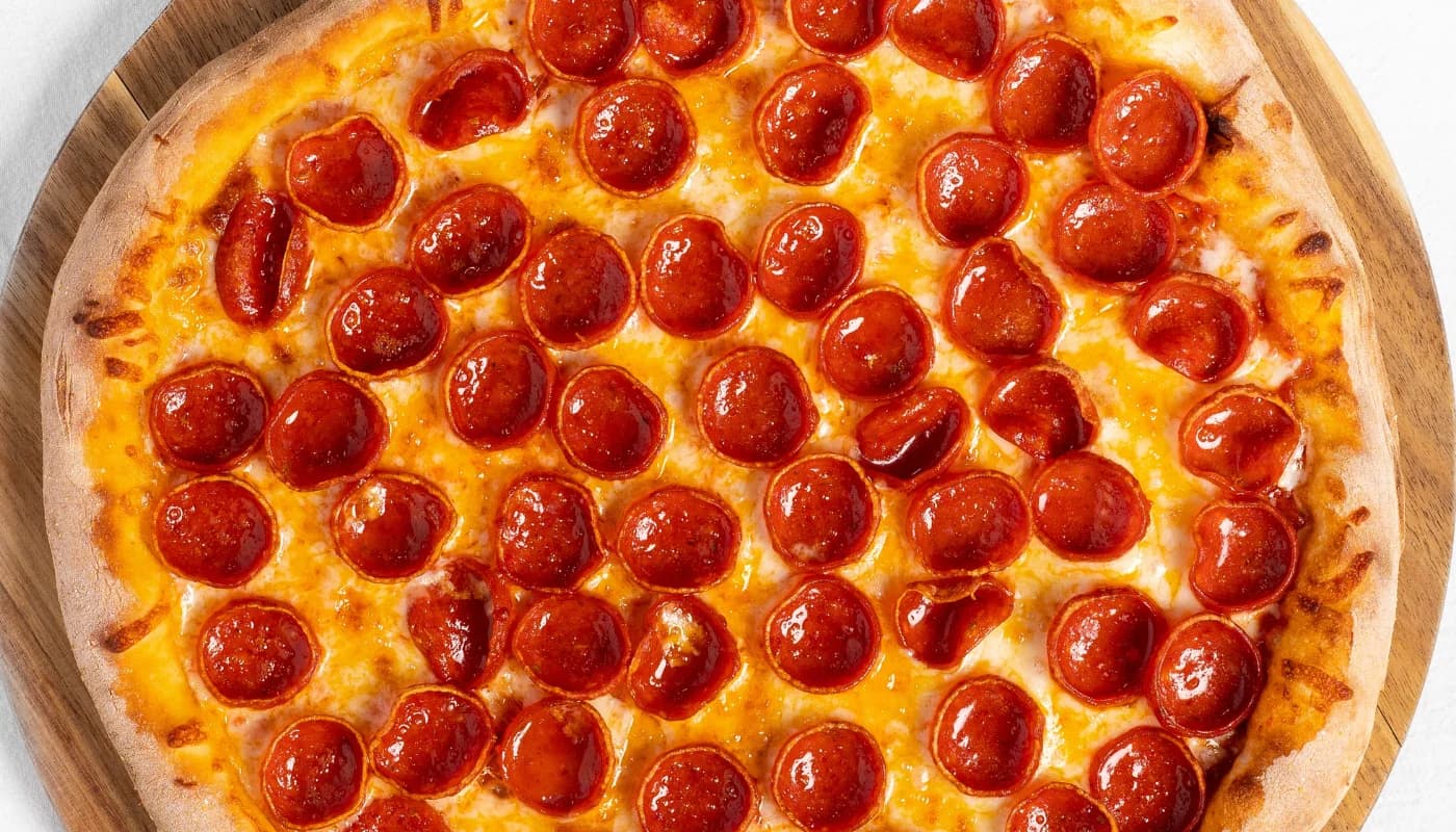 Una pizza de pepperoni recién salida del horno de leña