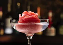 Every Rose Has Its Thorn cocktail: a pink rose-shaped ice in a coupe glass